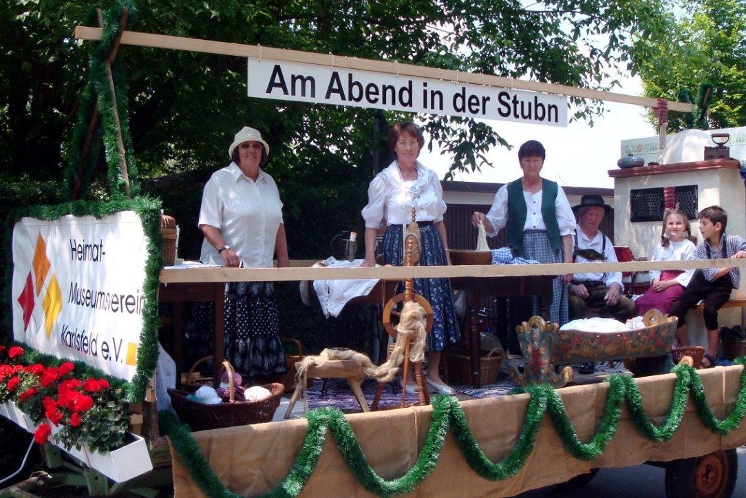 Gruppe Heimatmuseum auf dem Festzugwagen mit dem Motto "Am Abend in der Stubn".