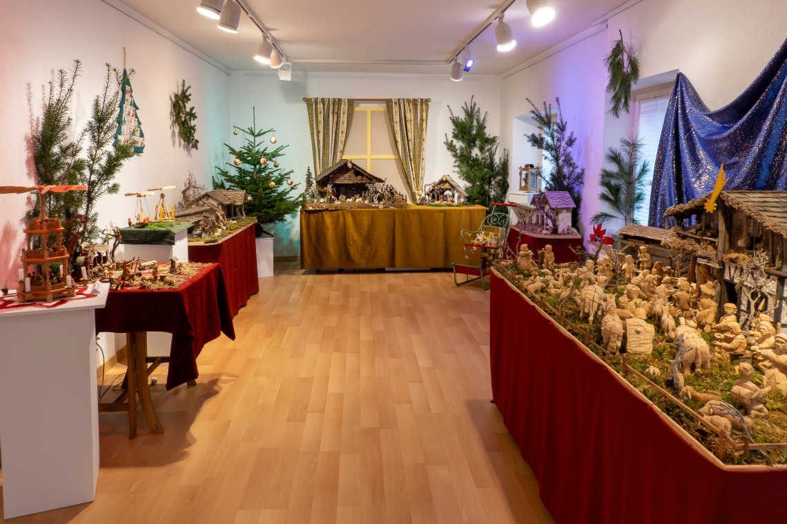Ausstellungsraum mit Krippen und Pyramiden, weihnachtlich dekoriert