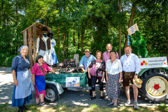 Der Umzugswagen mit Torfhütte und Karren mit Torf von einem Tracktor gezogen